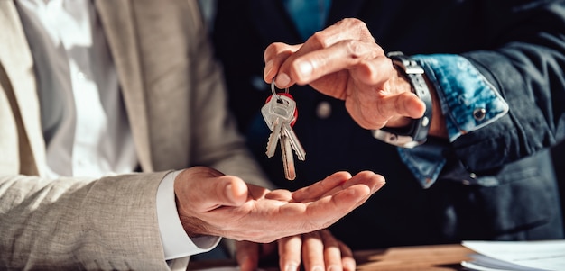 Real estate agent passing apartment keys to a client