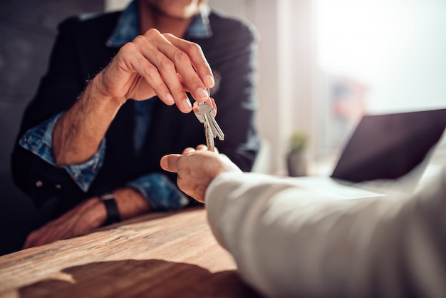 Real estate agent passing keys to his client