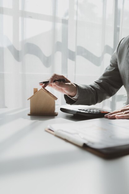 A real estate agent sits in her office The salesperson is presenting what the home the customer is about to buy looks like The broker is calculating the buyers monthly instalment payments