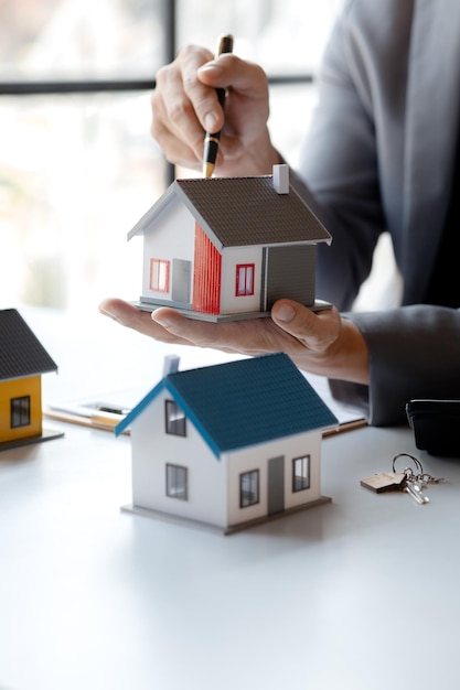 Real estate agents explain models of housing estates in projects to elaborate to clients explaining and presenting information about homes and purchasing loans Real estate trading concept