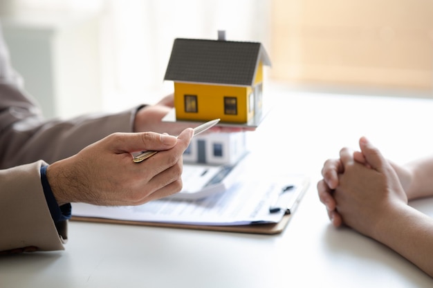 Real estate agents explain models of housing estates in projects to elaborate to clients explaining and presenting information about homes and purchasing loans Real estate trading concept