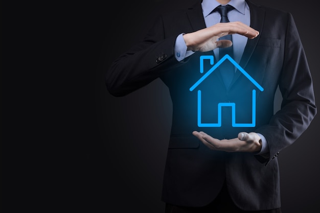 Real estate concept, businessman holding a house icon.House on Hand.Property insurance and security concept. Protecting gesture of man and symbol of house.