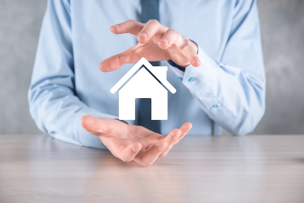 Real estate concept, businessman holding a house icon.House on Hand.Property insurance and security concept. Protecting gesture of man and symbol of house.