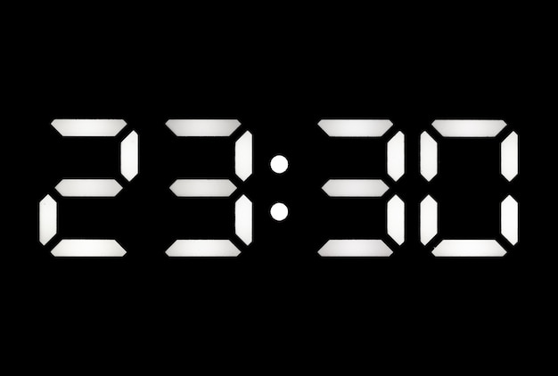 Real white led digital clock on a black background showing time 2330