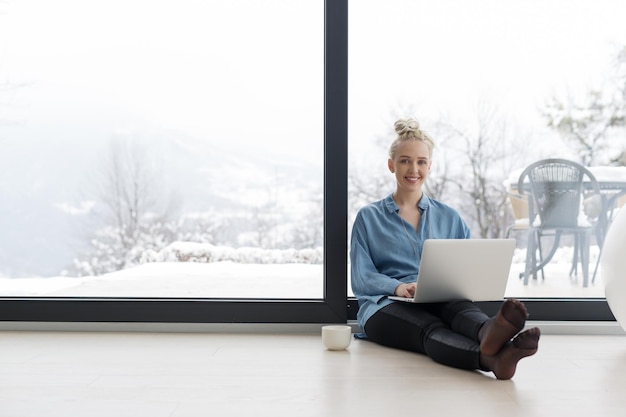 Real Woman Using laptop on the floor Drinking Coffee Enjoying Relaxing at cold winter day