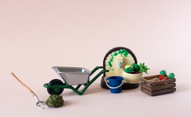 Realistic figures of farm or garden tools with box of vegetables