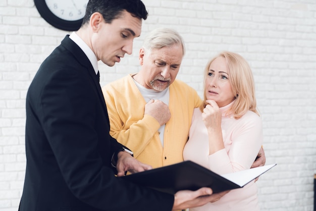 The realtor in a black suit is standing side by side.