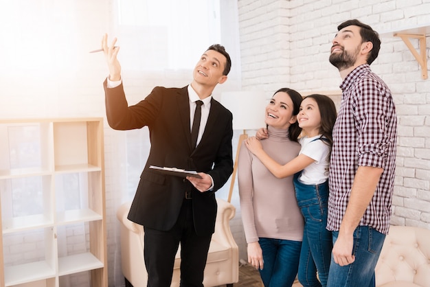 Realtor in suit shows family house they bought.