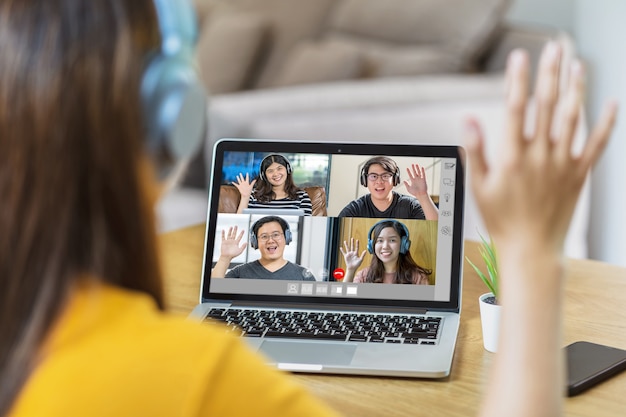 Rear View of Asian Business woman say hello with teamwork colleague in video conference