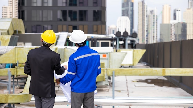 Rear view of business man and Office building owner and energy engineer plan a project to build a solar panel for the building under construction clean and green alternative energy concept