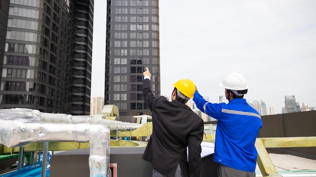 Rear view of business man and Office building owner and energy engineer plan a project to build a solar panel for the building under construction clean and green alternative energy concept