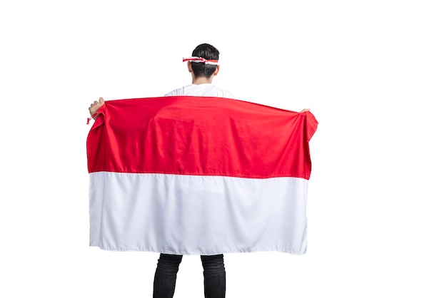 Rear view of Indonesian men celebrating Indonesian independence day on 17 August by holding the Indonesian flag