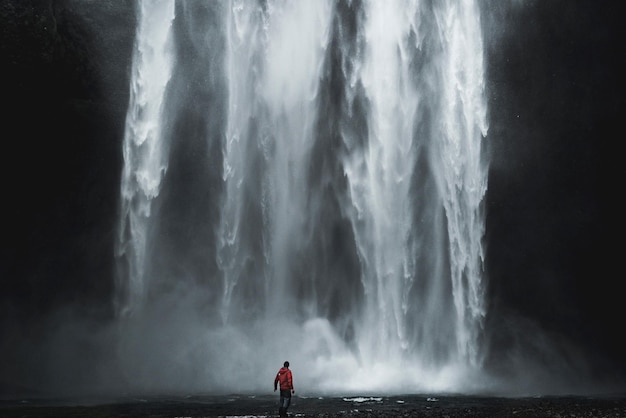 Rear view of man against waterfall