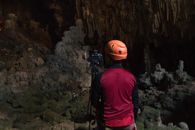 Photo rear view of man photographing in cave