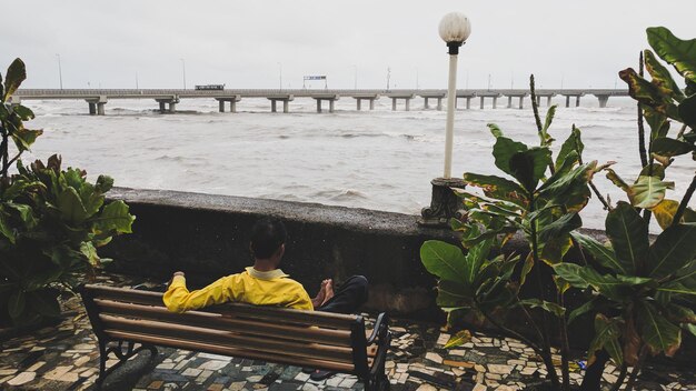 Photo rear view of man sitting on bench