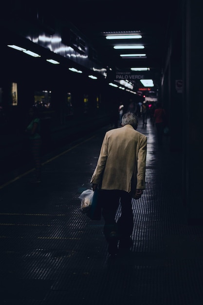 Rear view of man walking on at subway station