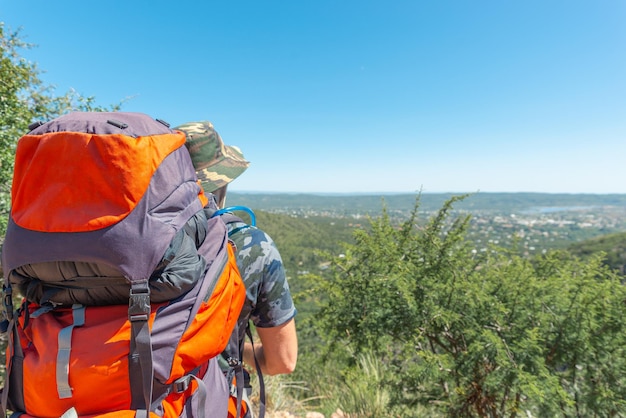 Rear View of Man Whit Backpack and Hat Looking the Horizon in a Sunny DayCopy Space