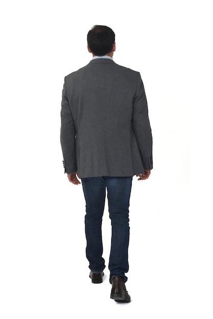 Rear view of a man with blazer walking on white background