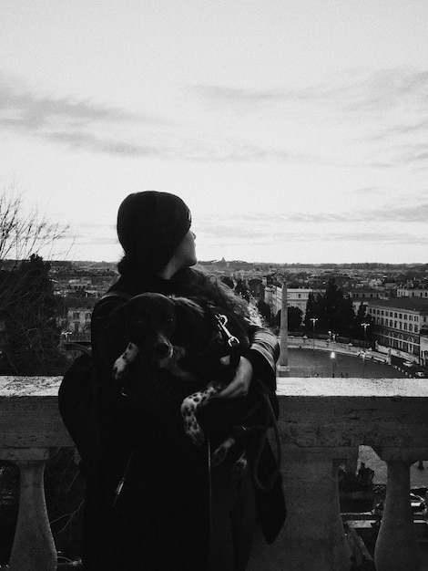 Rear view of man and woman standing against cityscape