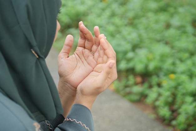 Rear view of muslim women hand praying at ramadan outdoor