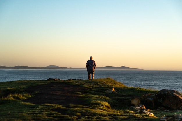 Rear View of Old Man Standing in the Edge of a Hill Looking the Sunrise.Lifestyle and Nature Concept