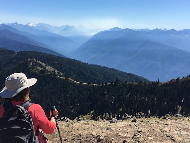 Rear view of people looking at mountains against sky