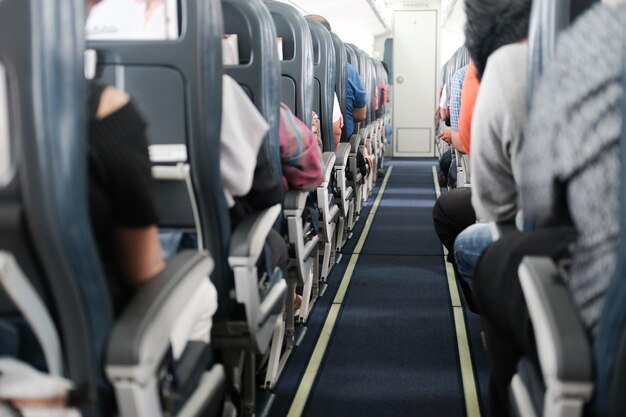 Photo rear view of people sitting on chairs in train