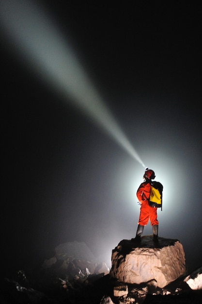 Photo rear view of person standing on rock against sky at night