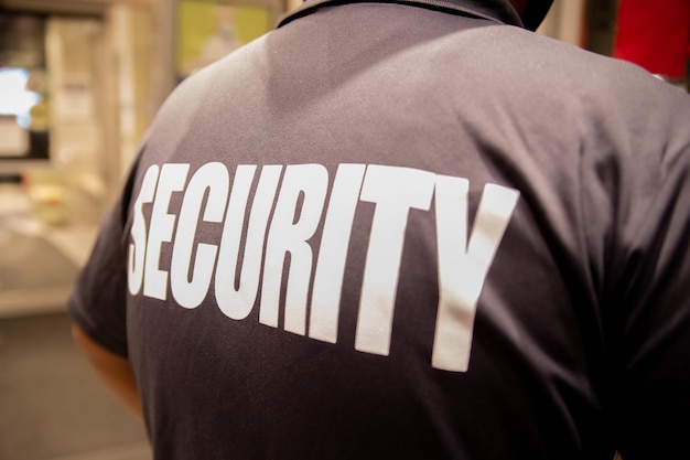 Rear view of a security guard in uniform patrolling in a commercial building.