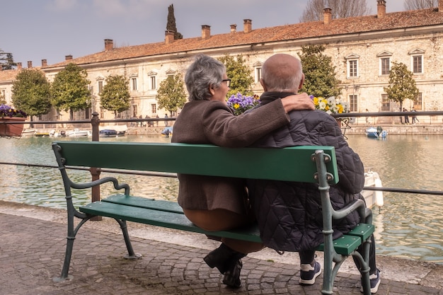 Rear view of a senior woman embracing her husband and looking the landscape with him