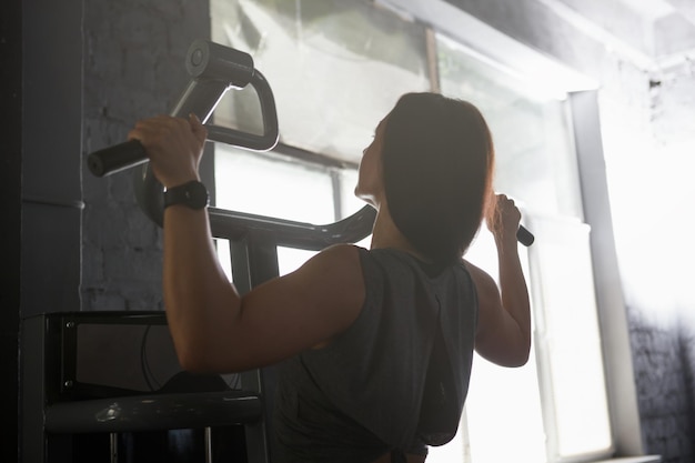 Rear view shot of a sportswoman doing pullups