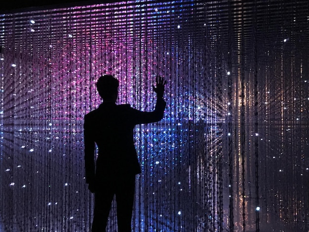 Rear view of silhouette man standing against abstract background