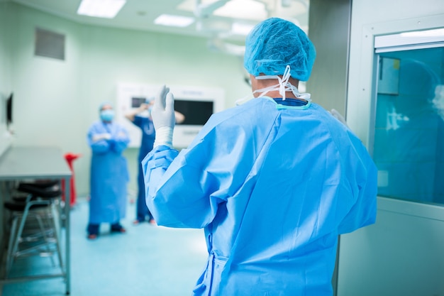 Rear view of surgeon walking in operation room