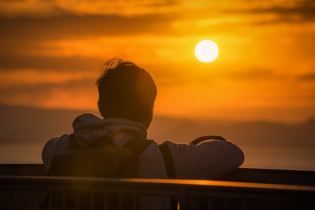 Rear view of Traveler man looking sea at sunset in Shizuoka, Japan.