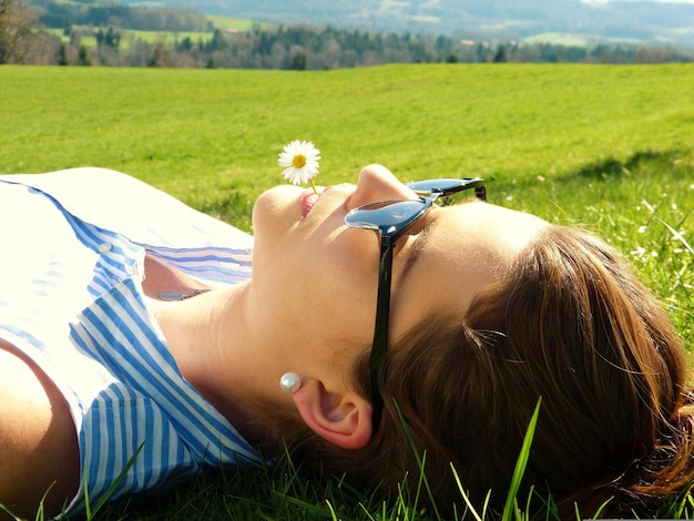 Rear view of woman lying on field