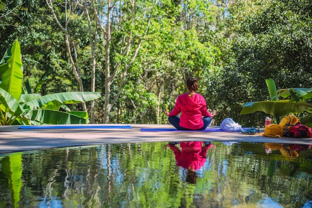 Photo rear view of woman meditating against plants