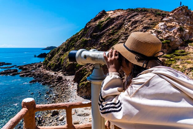 Photo rear view of woman photographing sea against clear blue sky