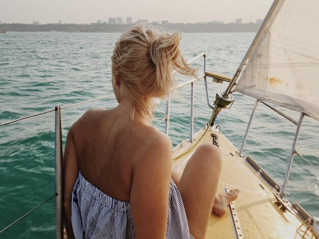 Photo rear view of woman sitting on boat sailing in sea