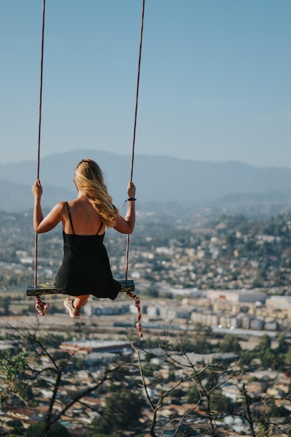 Photo rear view of woman on swing against clear sky