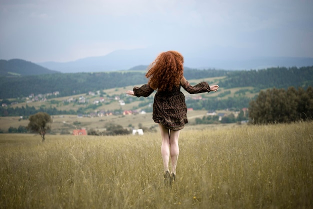 Rear view of woman walking on grassy field