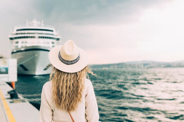 Photo rear view of woman wearing hat against sky