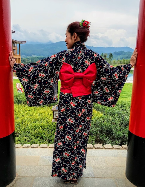 Photo rear view of woman wearing kimono standing on footpath