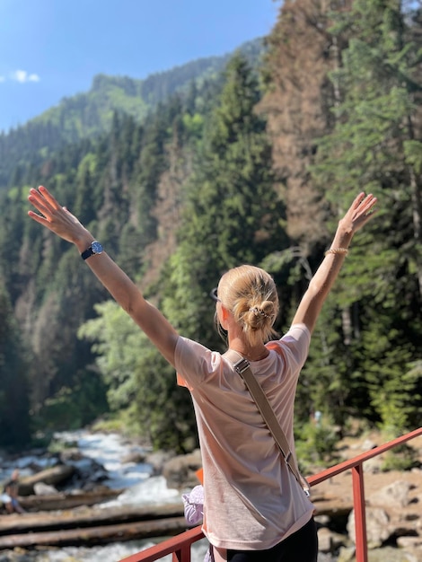 Photo rear view of woman with arms outstretched standing on mountain