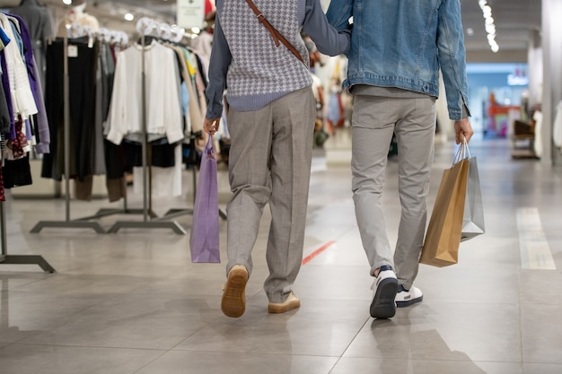 Rear view of young couple in casualwear walking in a clothing store