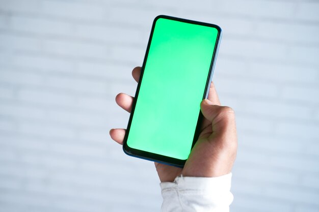 rear view of young man using smart phone indoor