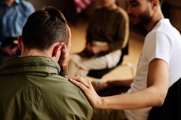 Rear view of young unhappy man suffering from loss or traumatic experience