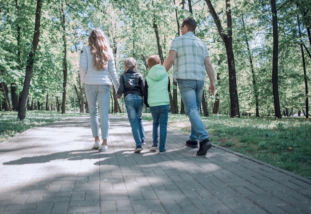 Rear viewmodern family on a walk in the Park spend leisure time together