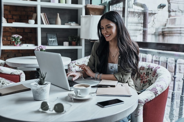 receiving good news. beautiful young smiling woman using laptop and smiling 