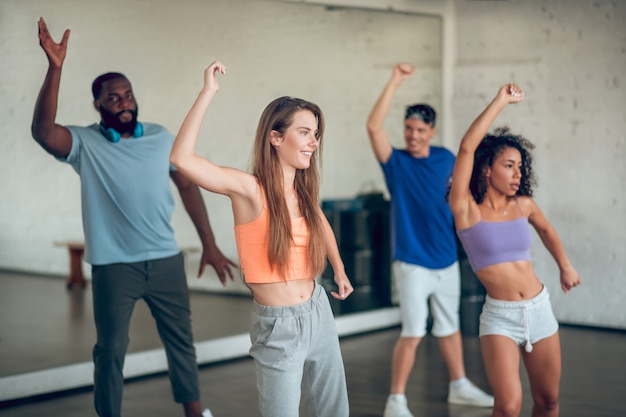 Reception. Group of young fit people in sportswear doing dance rehearsals 