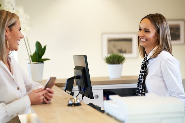 receptionist and businesswoman at hotel front desk